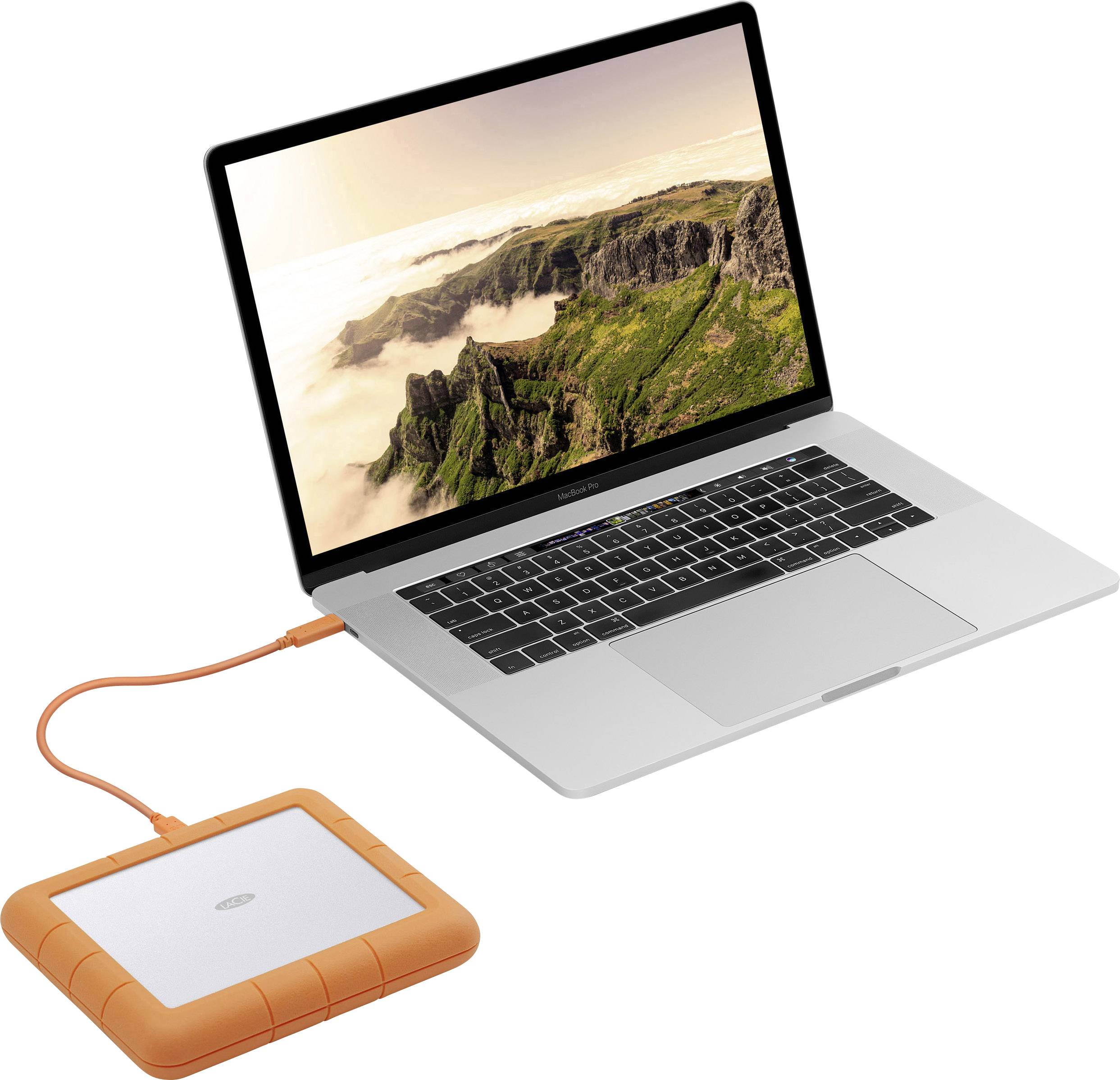 A laptop with a picture of mountains on the screen is connected to an orange external hard drive.