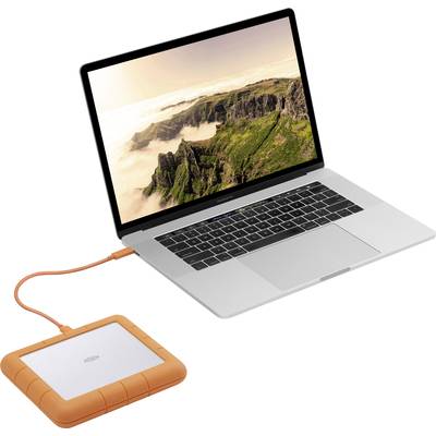 A laptop with a picture of mountains on the screen is connected to an orange external hard drive.
