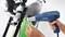 A person is using a hot air blower to attach a cable to a bicycle frame.