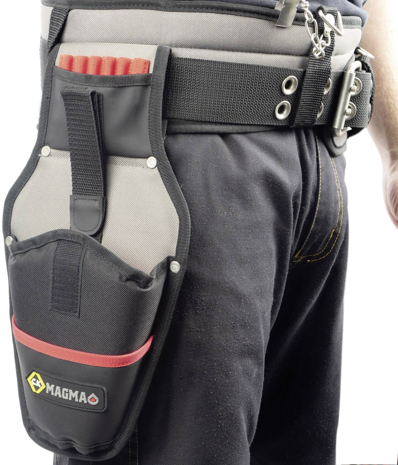 A person is wearing a black tool belt with a large pouch and red handles. The pouch features the 'MAGMA' logo.