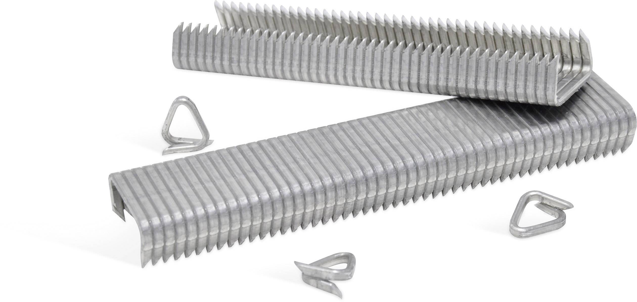 A stack of silver metal paperclips lies on a table, with loose paperclips scattered beside it.