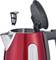 A red kettle with an open lid and removable filter, clearly visible in a kitchen setting.