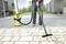 A person is vacuuming pebbles from a paved floor using a yellow industrial vacuum cleaner.