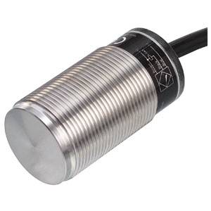 A cylindrical proximity sensor made of metal with a ribbed surface and a cable connection on the rear side.