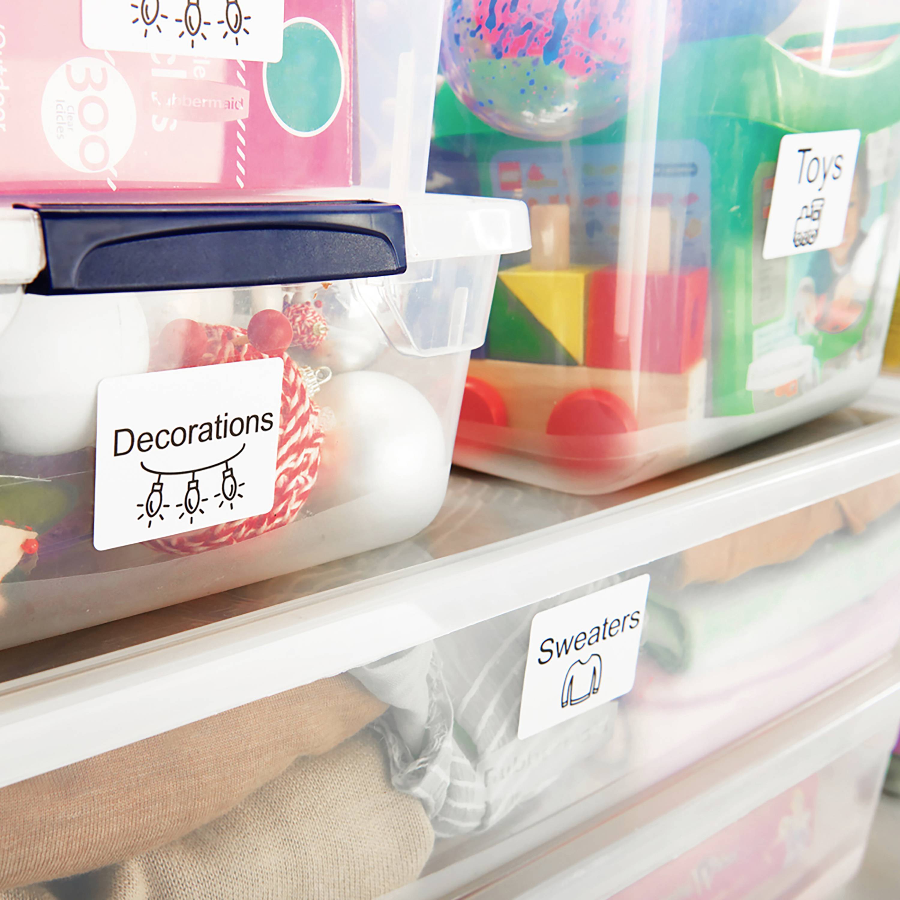 Plastic boxes with labels 'Decorations', 'Toys' and 'Sweaters', filled with Christmas decorations, toys and jumpers.