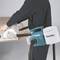 A person is sawing wood with a Makita electric handheld circular saw. Dust is being collected in an attached bag.