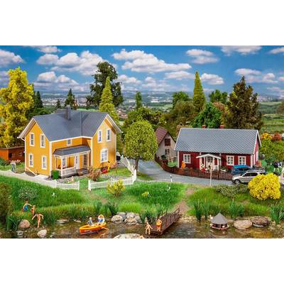 A miniature landscape depicts two coloured houses, trees, and figures by a pond. People are swimming and boating on a sunny day.