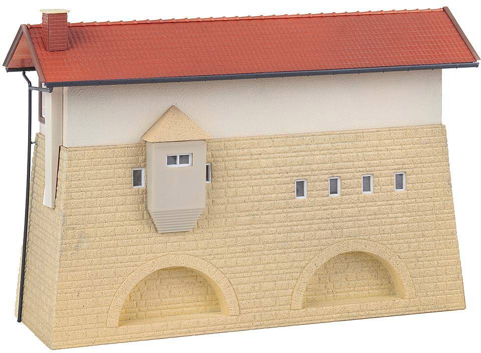 A model building at a miniature scale with a red tiled roof, beige façade and architectural details such as arches and windows.