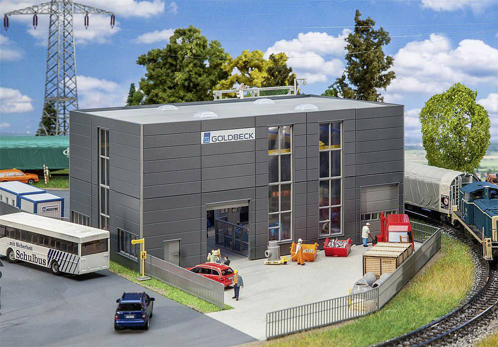 A miniature representation of a modern industrial facility with employees, vehicles, and a train in the foreground.