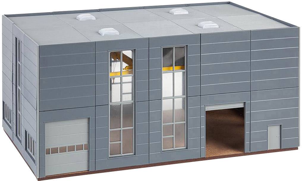 A rectangular grey industrial building with large windows and a wide entrance on the right side, mounted on a plinth.