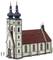 A church with red tiled roofs and two tall towers with onion-shaped domes. The façade is white with decorative elements.