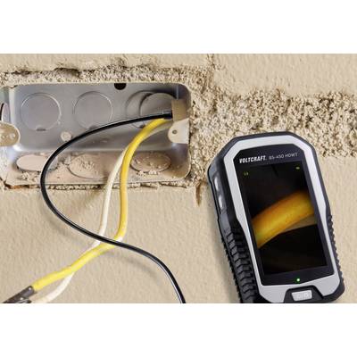 An open socket with exposed yellow cables, next to a handheld device with a screen displaying details of the cable connection.