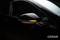 Black car with illuminated side mirror indicator.