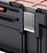 Black plastic storage box with red lid, rectangular handle at the front. Used for secure transportation or storage.