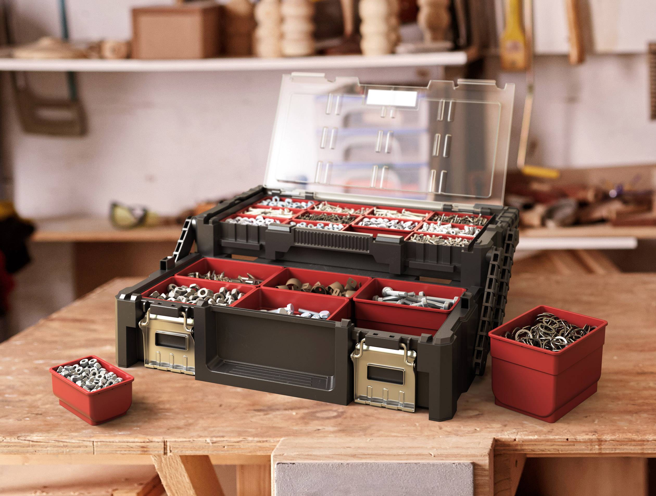 An open tool case with red compartments filled with screws and nails resting on a workbench in a workshop environment.