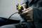 A person in workwear is holding a tool with which they are cutting or working on a cable.
