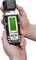 A person is holding a digital moisture metre with a green illuminated display. The device is showing moisture readings that fall between 'dry' and 'wet'.