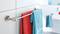 Two towels, one red and one blue, are hanging on a towel rail in the bathroom. A washbasin can be seen in the background.