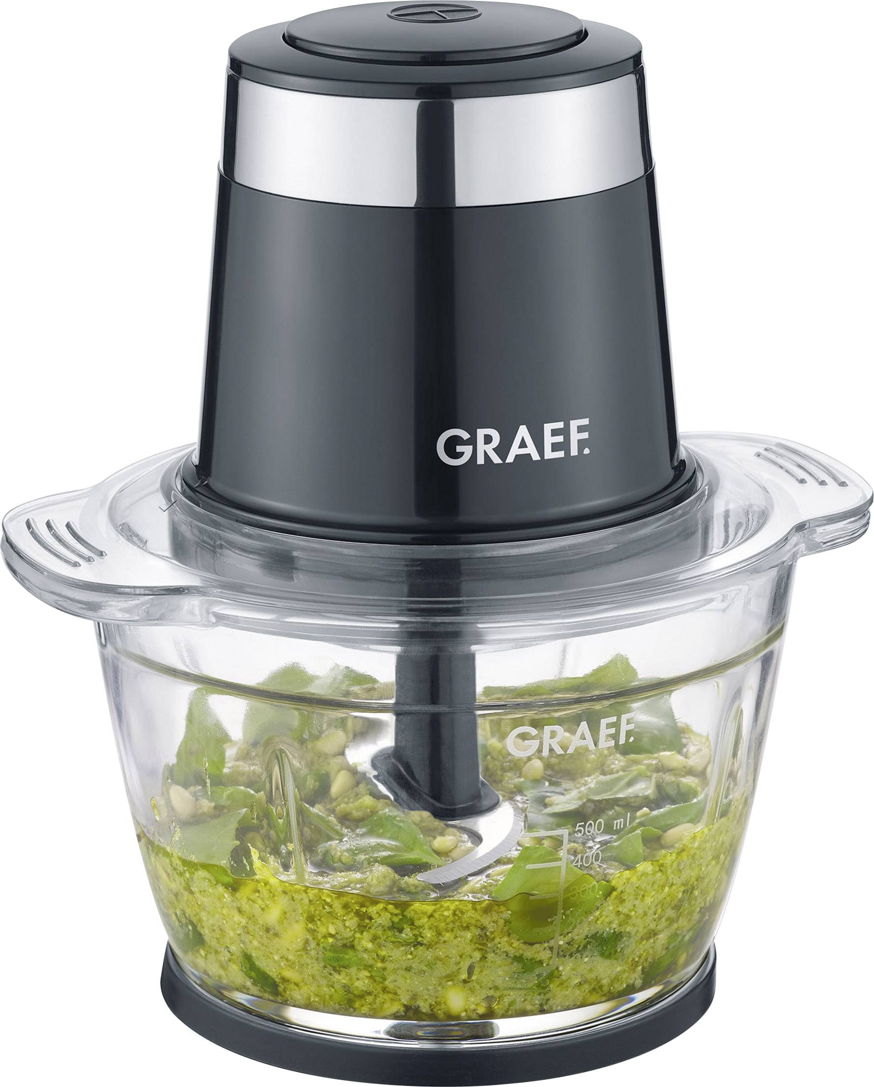 Electric blender with a black casing, transparent container, and green mixture of herbs and nuts inside.