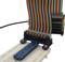 A flat ribbon cable is connected to an electronic circuit board mounted on a breadboard.