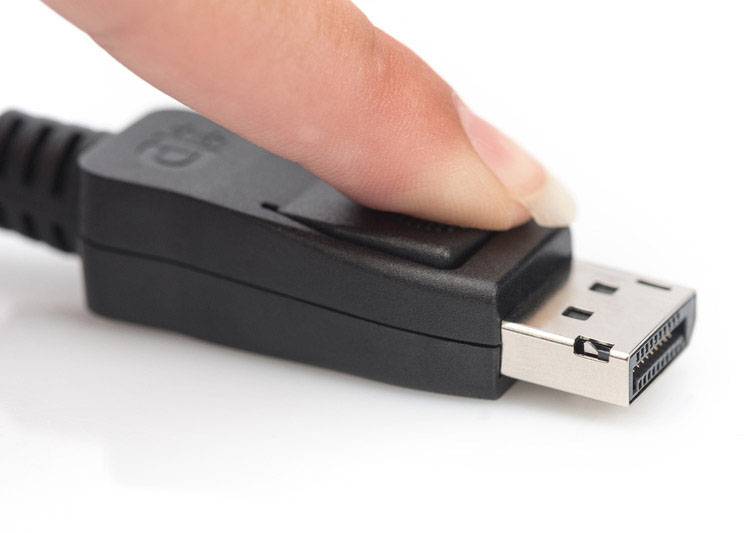A finger presses the release button of a DisplayPort plug. The plug is partially visible in close-up.