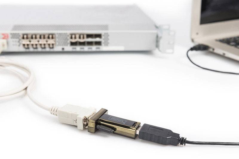 A laptop is connected via a USB cable to a network device that has multiple Ethernet ports.