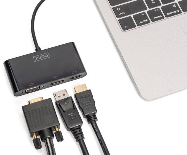 An adapter with various ports (HDMI, VGA, USB) is connected to a laptop.