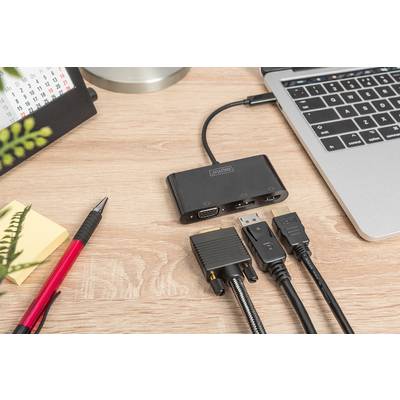 An adaptor connects several cables to a laptop on a desk; beside the laptop are notes, a pen and a calendar.
