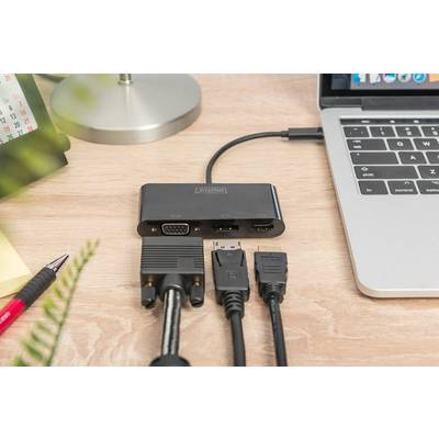 A laptop is connected via an adapter with multiple cables. The adapter provides VGA, HDMI, and DVI ports for different connections.