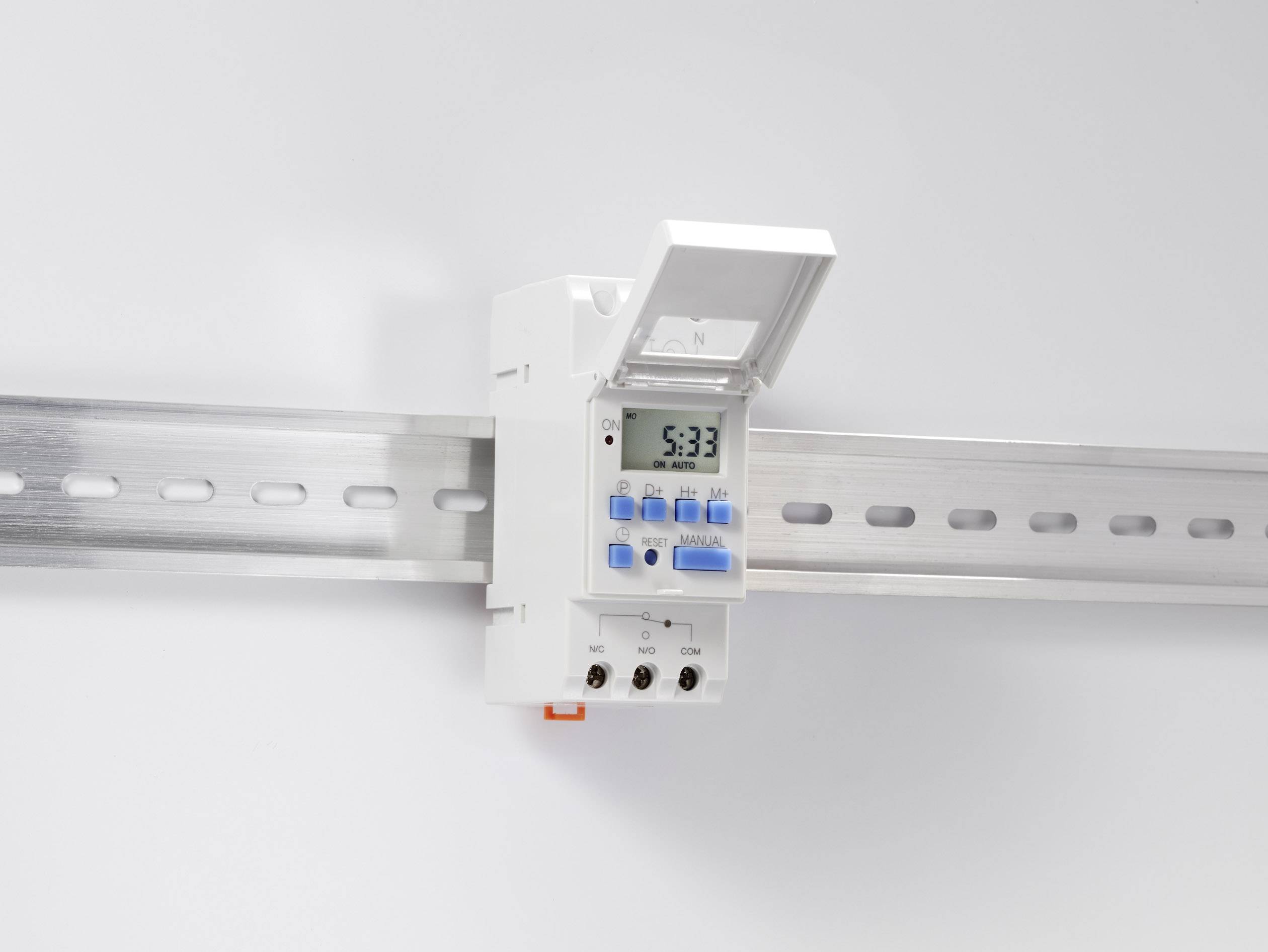 A digital wall-mounted timer with an open lid, attached to a metal rail, displays the time as 5:33.