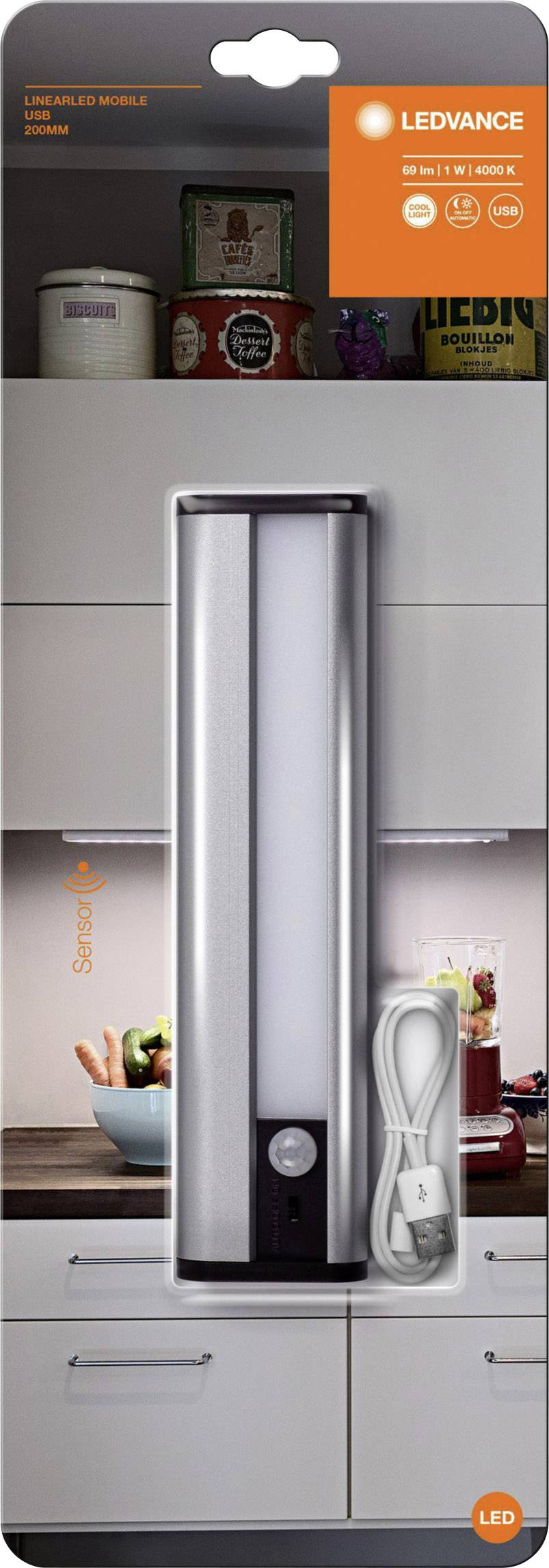 LEDVANCE sensor light in packaging with USB cable. Background shows a modern kitchen with wall cabinets and decorative elements.