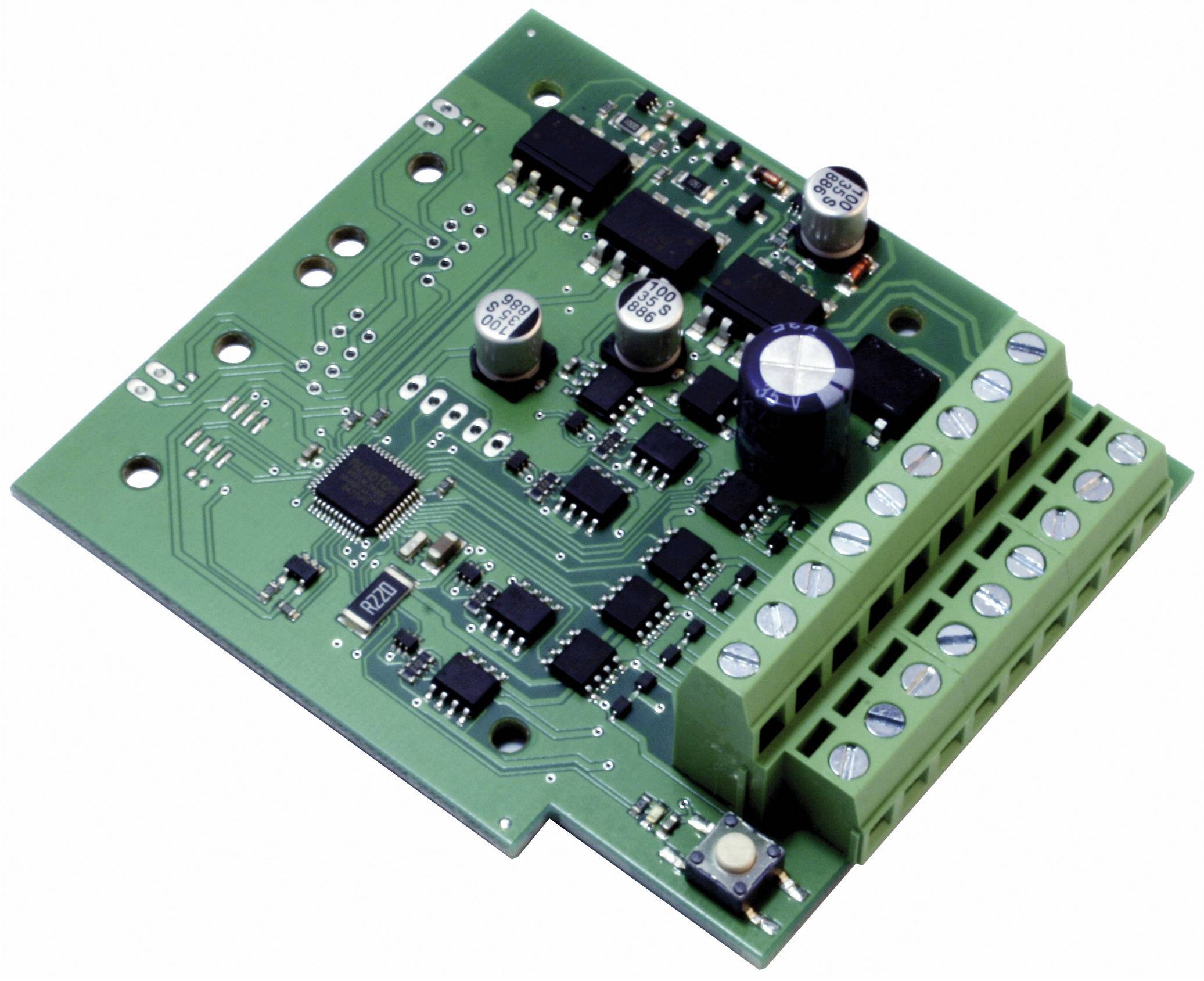 A green printed circuit board with numerous electronic components, including chips, capacitors, and terminal blocks.