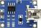 A blue circuit board displays a USB port, several capacitors and resistors. Labelled with B+ and B- for battery contacts.