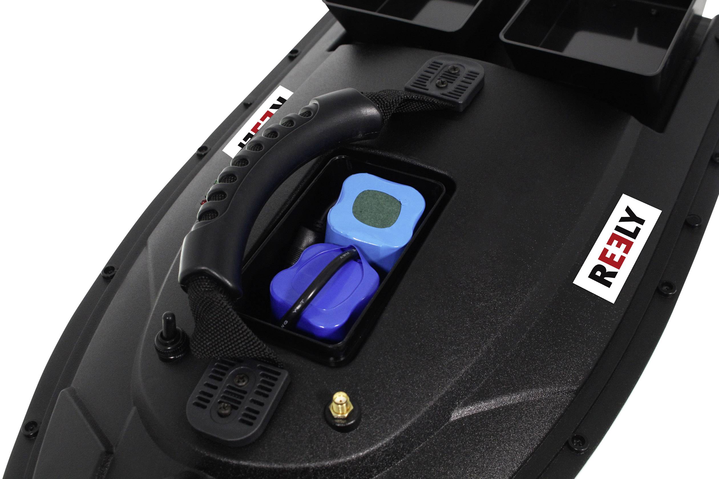 Black remote-controlled boat by REELY with blue battery under a removable cover; visible carry handle and switch.
