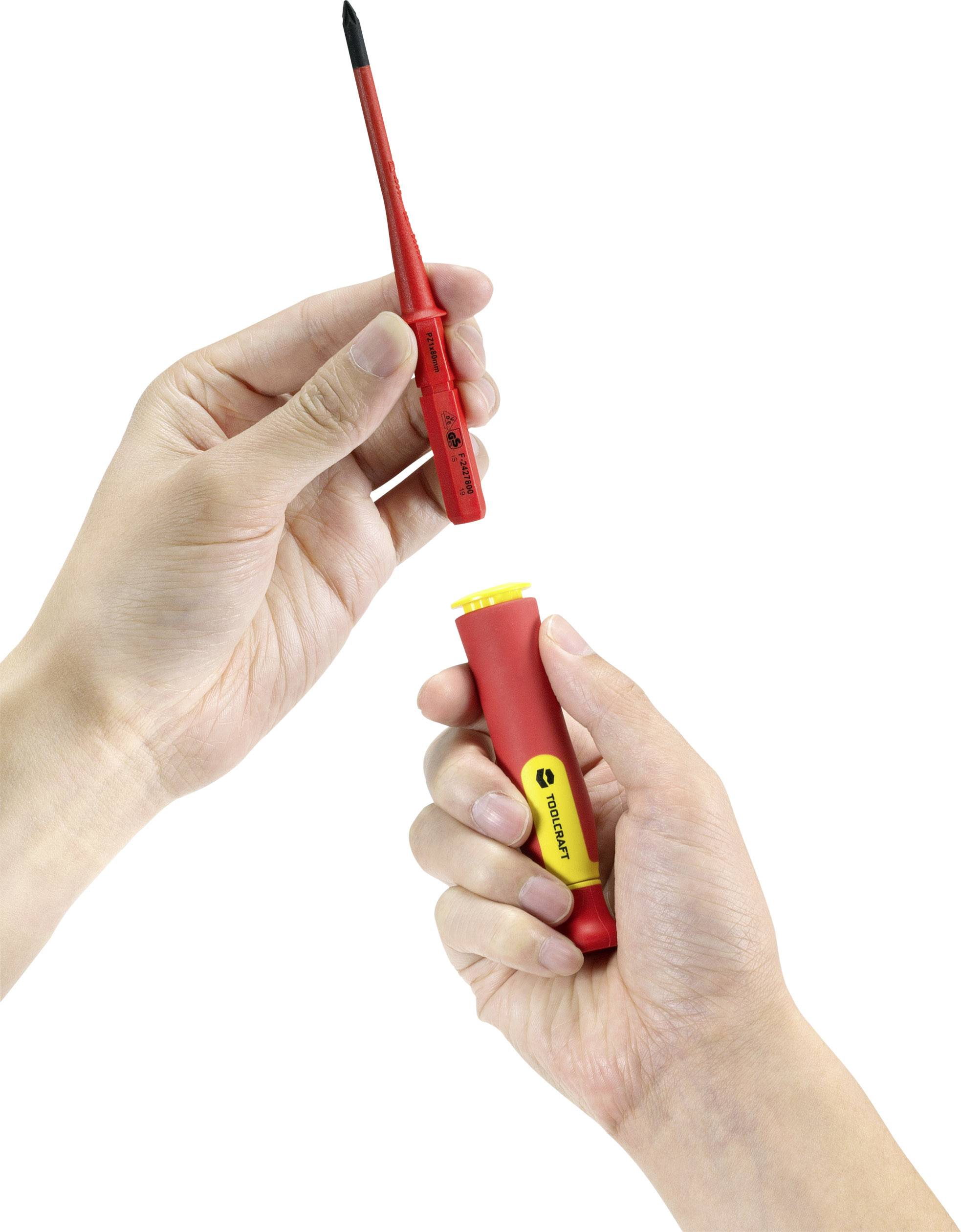 A person is holding a red screwdriver with a detachable handle. The upper hand is pointing to the screwdriver, while the lower hand is gripping the handle.
