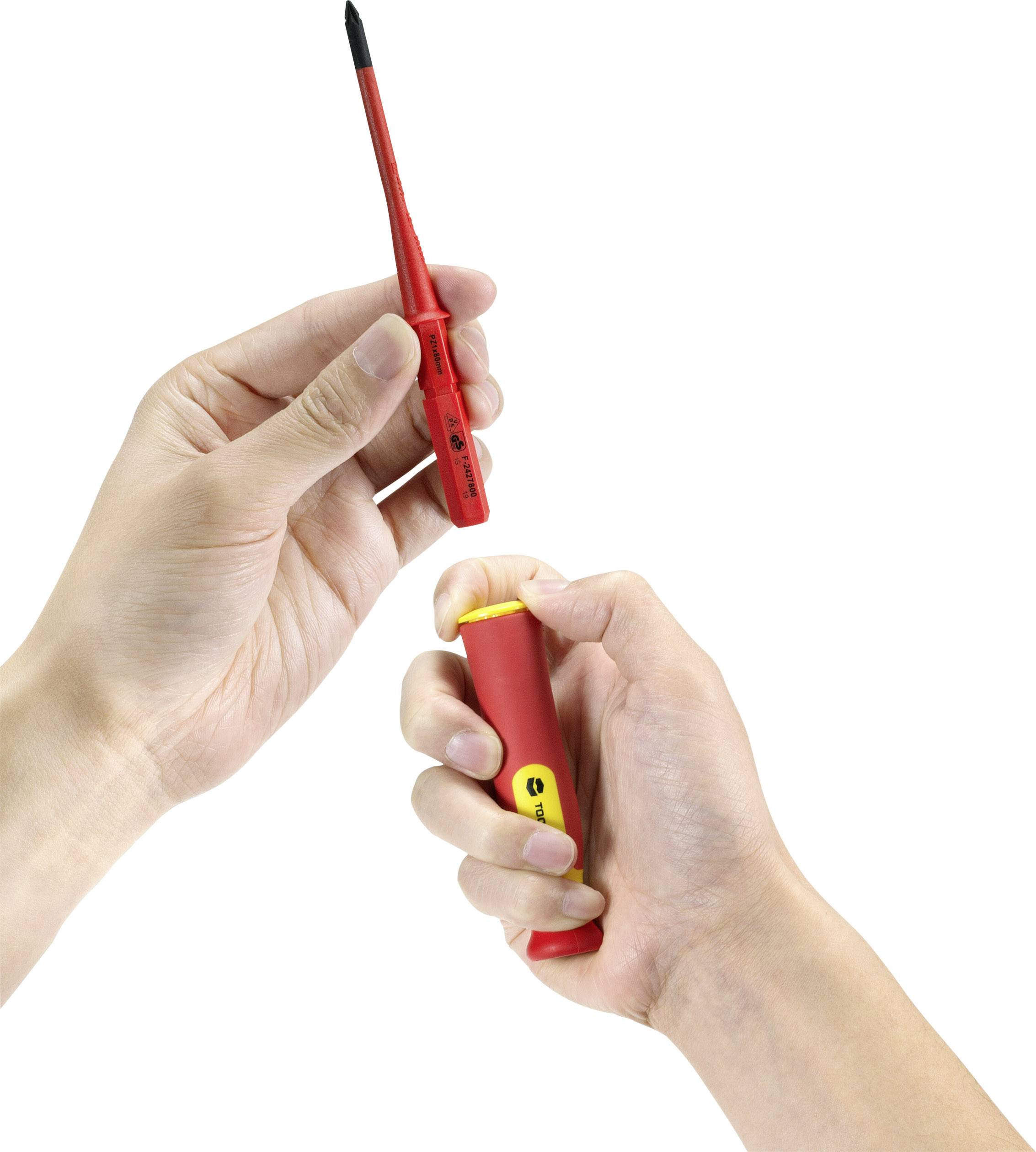 Two hands are holding a red screwdriver with a yellow label. One hand has removed the cap and is showing the tip.