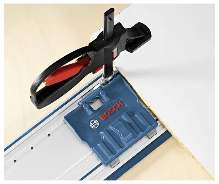 A precision guide tool clamped to a wooden board, showing blue 'BOSCH' branding, positioned for straight cutting or alignment.