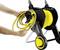 A person is winding a yellow garden hose onto a black hose trolley with yellow wheels, with the brand markings visible.