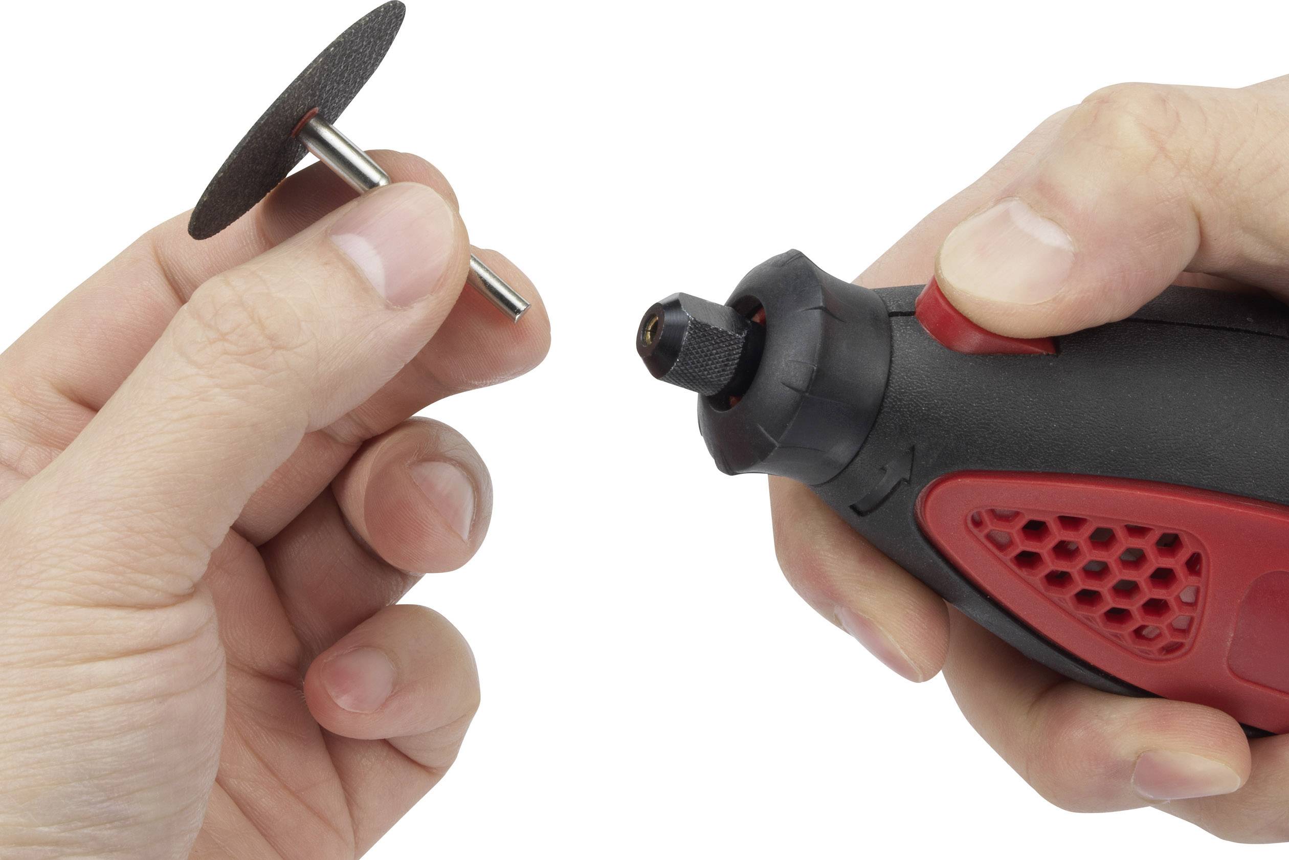 A person is holding a compact red and black electric tool in their right hand and a small grinding disc in their left hand.