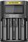 A black Nitecore charger with four inserted batteries and a digital screen displaying the charging status.