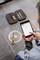 A person is operating a tablet to measure data, with tools lying beside them on a floor drain.