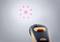 An infrared thermometer shows red laser points in a circle. It is used to measure the surface temperature.