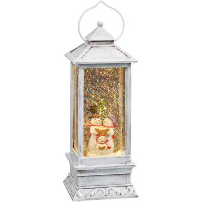 White lantern with a snowman family inside and a glittering, snow-covered background.