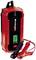 Red Einhell car battery charger with digital display showing '13.4V'. Two cables with clamps for connection.