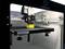 A 3D printer is printing a yellow object. Warning sign on the platform: 'Caution - Hot Surface / Caution High Temperature'.