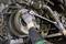 A person wearing gloves is using a torque wrench to work on a mechanical component, possibly an engine.