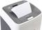 A paper shredder with multiple sheets of paper inserted from the top. Device is ready for use, green operational indicator is lit.