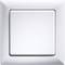 A square light switch with a white frame on a wall.