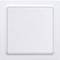 A white light switch in a square shape on a white wall, untouched.