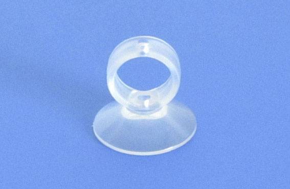 A transparent suction cup on a blue background, used for attaching light objects to smooth surfaces.